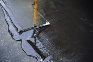 sealcoat being applied to pavement