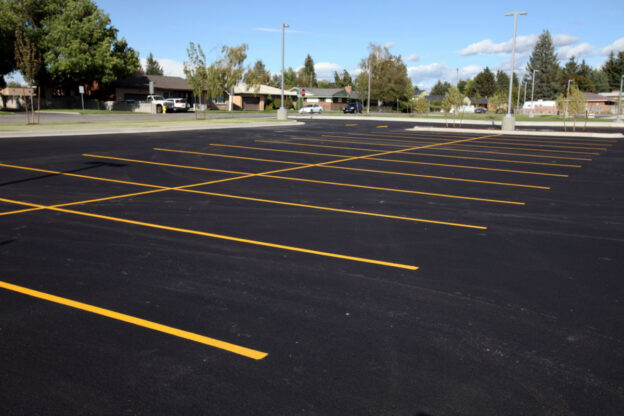 A parking lot that has been freshly paving with freshly-painted parking space lines.