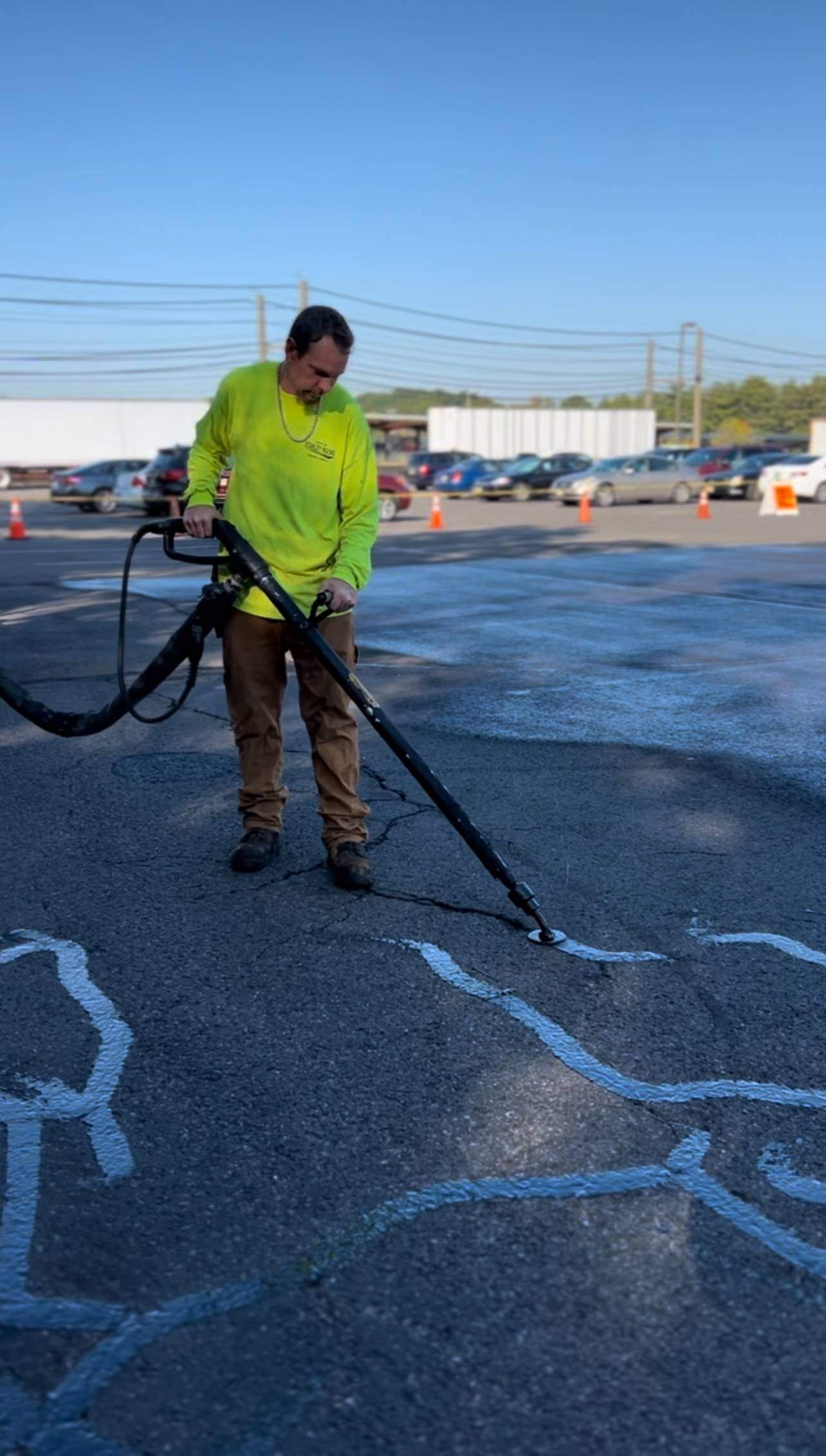 Stanley Paving worker applying hot rubberized sealant for asphalt crack repair on a parking lot prior to the school year in NJ and PA.